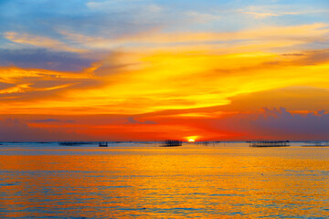 sunset in the sea. Beautiful colorful sky and cloud in twilight time background. Orange fluffy clouds and sun sunlight reflection in the blue sky.