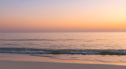 Fototapeta premium Peaceful Beach Sunset with Soft Ocean Waves and Pastel Sky