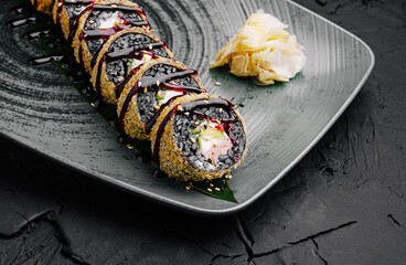 Sushi roll served on a textured plate with garnishes