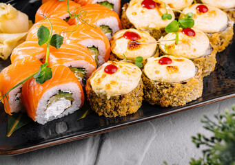 Gourmet sushi platter with assorted rolls, garnished with herbs and sauce
