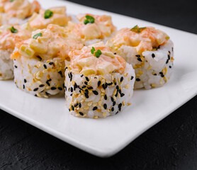 Delicious sushi rolls platter on dark background