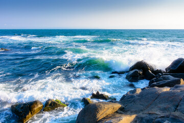 rocks at the black sea shore in summer. waves crashing coast of bulgaria on a sunny morning....