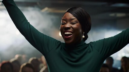 Enthusiastic Black woman singing with hands raised in a smoky atmosphere, expressing joy in a dark room, celebrating success with celebration among a group of people.