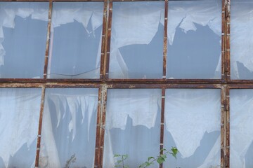 Old building with rusty metal frames and broken windows — symbol of decay, time, and urban...