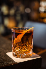 Negroni cocktail on the bar, bo. equal parts gin, vermouth rosso, and Campari, garnished with an...
