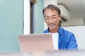 ノートパソコンを使うシニア男性