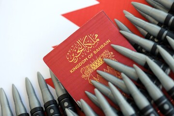 Bahraini passport and rifle bullets on flag. The concept of warfare and gun selling