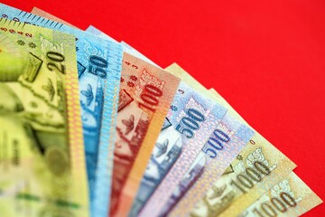 Thai baht money bills in big amount on red. Finance and banking concept