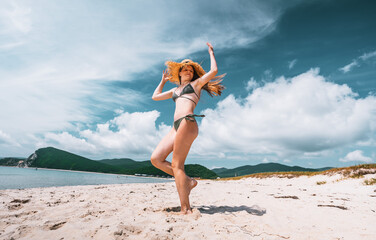 Beautiful young female posing on beach with charm and grace. Her elegant movements and radiant energy show confidence, freedom, and connection with nature in vacation setting.