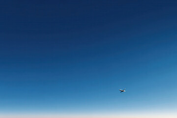 Fototapeta premium photorealistic ultraminimalistic depiction of clear blue sky with solitary airplane in distance