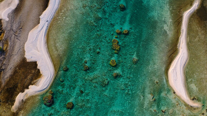 Aerial view of turquoise waters embracing the soft, sandy shores of a tropical paradise, creating a mesmerizing contrast of colors and textures, French Polynesia.