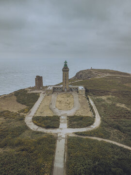 Aerial view of the imposing Cap Fr&Atilde;&copy;hel lighthouse stands sentinel against the moody sky, a testament to coastal fortitude, Pl&Atilde;&copy;venon, Bretagne, France.