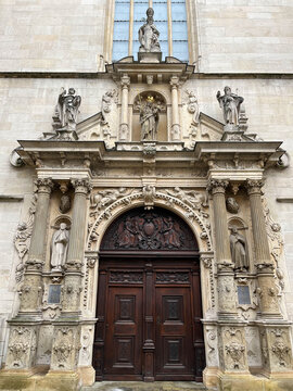 Wooden door of Luxembourg Cathedral, in an arch with carved images around it.