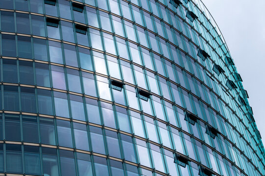 Curved glass tower in financial center, reflecting sky and modern economy, symbolizing progress, innovation, corporate growth and global investment identity