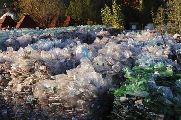 Mountains of compressed plastic bottles prepared for recycling — a symbol of the modern...