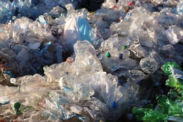 Mountains of compressed plastic bottles prepared for recycling — a symbol of the modern...