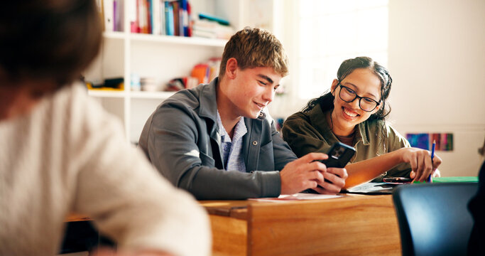 Education, students and friends with mobile in classroom for research, online course or smile. Teenager, boy and girl with phone for learning, scholarship or chat for high school curriculum with app