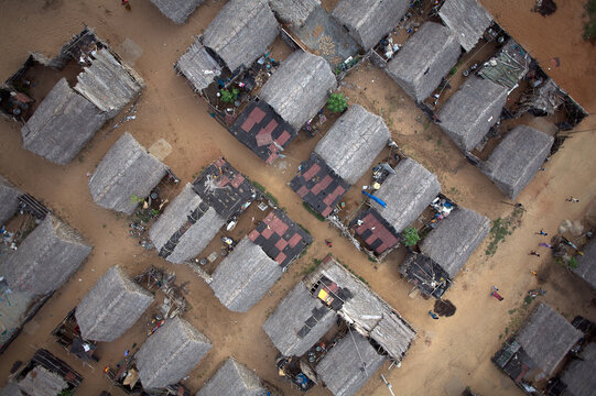 Aerial view of thatched roofs and sandy paths create a textured mosaic in the relocated village, a testament to resilience, Mahabalipuram, Tamil Nadu, India.