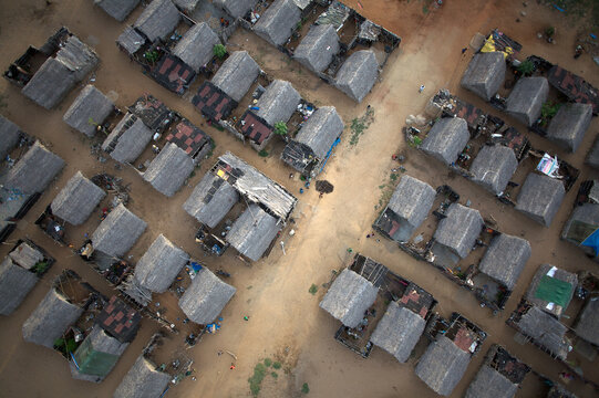 Aerial view of a settlement with tightly packed huts and sandy paths creating a textured mosaic of earthy tones, Post-tsunami relocated village, Mahabalipuram, Tamil Nadu, India.