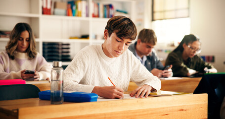 Boy, student and writing with books in classroom for higher education, learning or development....