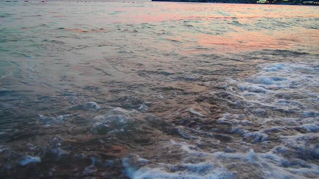 Morning light bathes the shores of Canj, Montenegro, as waves crash and retreat on the sandy beach. The tranquil Mediterranean environment invites relaxation and peace