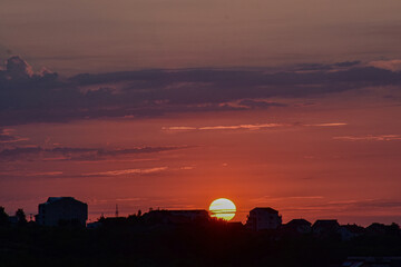 Fototapeta premium Sunset sky with magical colors above city skyline silhouettes.