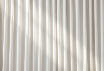Obraz premium Soft, sheer curtains diffuse sunlight, casting delicate shadows on a neutral wall.