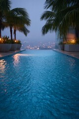 Obraz premium Nighttime pool with city lights and palm trees.