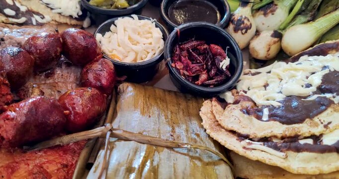 Detail shot of Oaxacan dishes, showcasing sausages, vegetables, edible insects, legumes, tamales, and mole, representing the diversity of this UNESCO Intangible Cultural Heritage