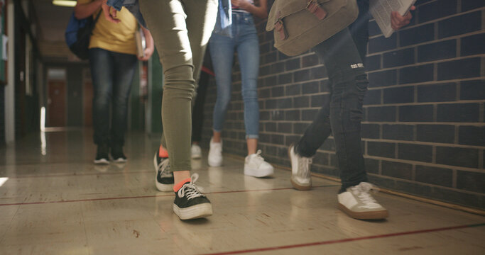 School, legs or children walking in hallway, education or skill development in morning lesson. Knowledge, study or teen students with bags in corridor, curriculum or hurry for interesting class - Powered by Adobe