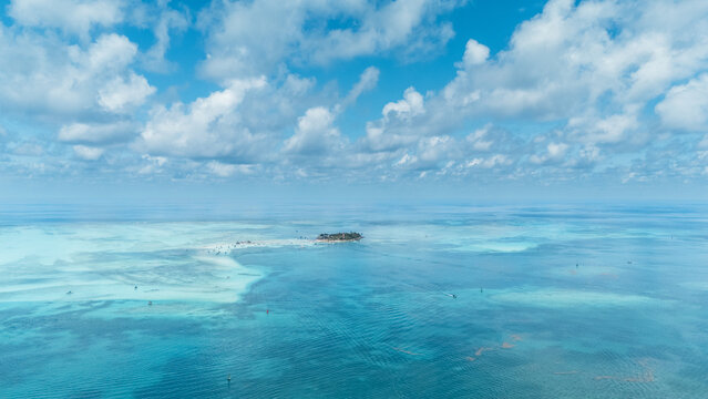 Aerial view of a small island surrounded by an array of turquoise and azure waters, where the sea meets the sky in a seamless blend of color, San Andr&Atilde;&copy;s, San Andres and Providencia, Colombia.