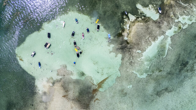 Aerial view of an island with shallow turquoise waters dotted with people and boats, contrasting with the surrounding deeper blue, San Andr&Atilde;&copy;s, San Andres and Providencia, Colombia.
