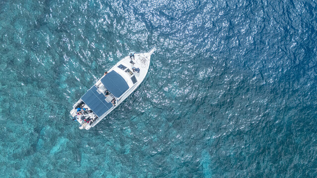 Aerial view of a boat sailing on the clear turquoise waters, contrasting with the white hull and blue canopy, San Andr&Atilde;&copy;s, San Andres and Providencia, Colombia.
