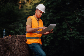 Forestry engineer examining plans in a forest