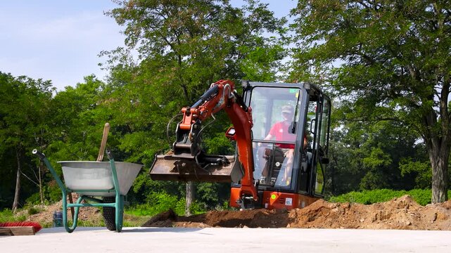 Mini excavator working at suburban construction site