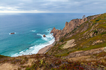 Fototapeta premium A sweeping coastal vista with turquoise waves crashing onto a sandy shore