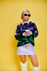 Stylish blonde woman showcases vibrant fashion in a modern studio setting