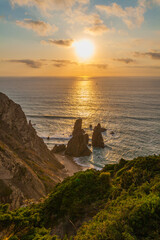 A breathtaking sunset over a rugged coastline with golden light reflecting on the ocean