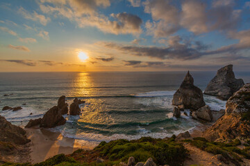 A breathtaking sunset over a rugged coastline with golden light reflecting on the ocean