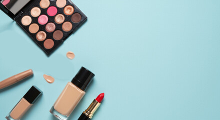 Makeup essentials on blue background with copy space
