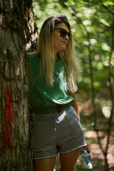 Woman resting with water bottle in forest