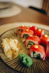 A delicious plate of fresh sushi rolls topped with tuna and a touch of sauce.