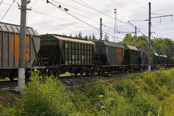Obraz premium Freight Train Cars Loaded with Cargo Traveling on a Remote Rural Track in Natures Landscape
