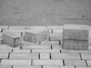 Row of bricks are laying on a gray sidewalk
