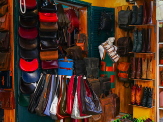 Colorful Western leather boots, studded handbags, backpacks fill artisan shop in Hoi An. A...