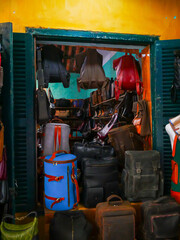 Studded handbags, duffel bags, and backpacks in bold colors fill vibrant Hoi An leather shop....