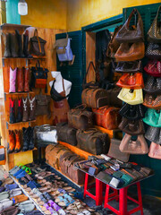 Sandals, backpacks, handbags, and wallets fill this Hoi An, Danang leather shop. A mannequin with a...