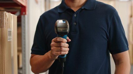 Worker scanning bar code on cardboard package with handheld scanner in warehouse. - Powered by Adobe