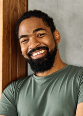 Portrait of a young happy black man posing at home or in the office