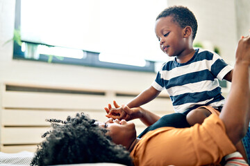 Portrait of mother and son having fun at home in bedroom, family life, parenting, love and bonding...